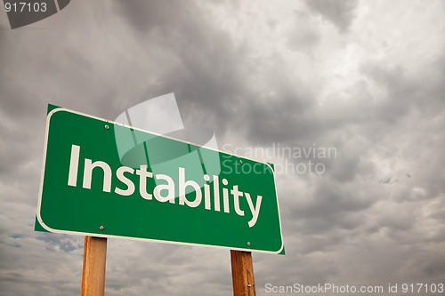Image of Instability Green Road Sign Over Storm Clouds
