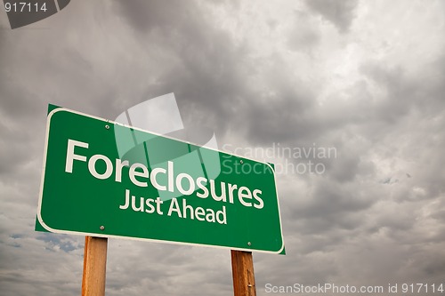 Image of Foreclosures Green Road Sign Over Storm Clouds