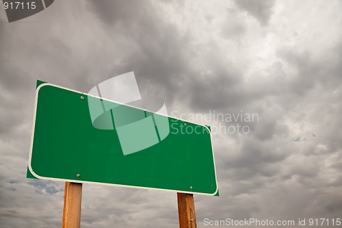 Image of Blank Green Road Sign Over Storm Clouds