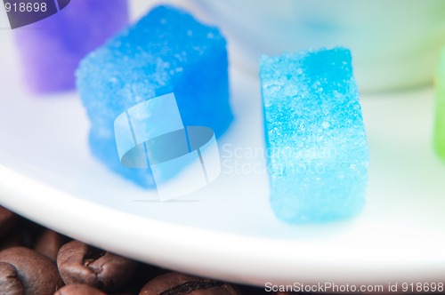 Image of Multicolored slabs of shugar and cup of coffee 