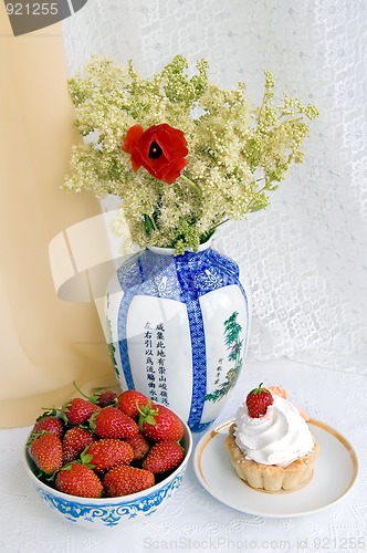 Image of Strawberries, cake and a vase with flowers