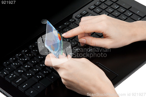 Image of Feminine hands with bank card on keyboard