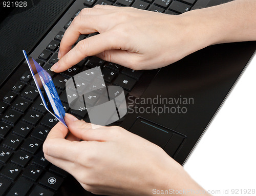 Image of Feminine hands with bank card on keyboard