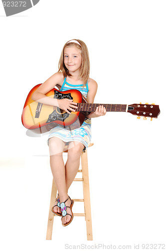 Image of Young blond girl with guitar.