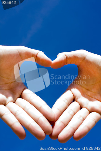 Image of Heart combined from hands on blue background 