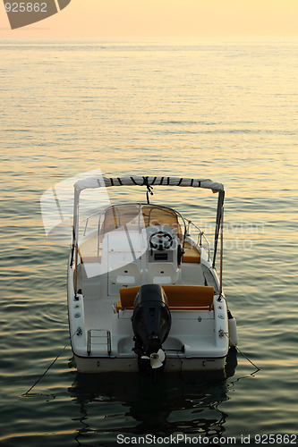 Image of backside of motorized boat with sunset