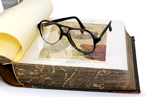 Image of An open old book and spectacles