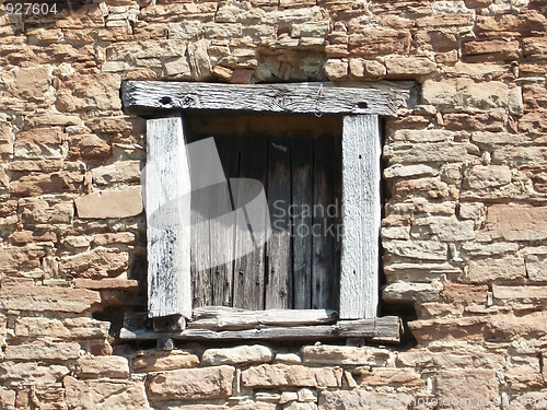 Image of The old wooden window in a stone house