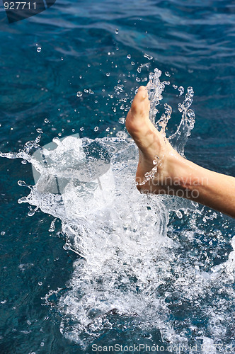 Image of Foot of young man in water - splash