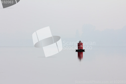 Image of red buoy on river in mist