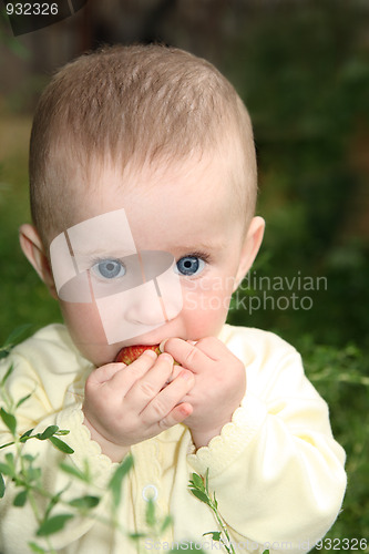 Image of baby biting apple in grass