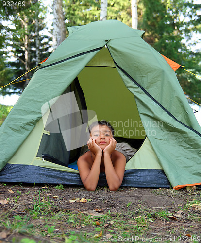 Image of thoughtful boy in camping tent