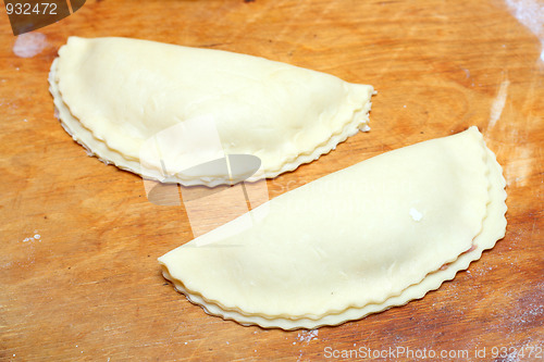 Image of raw patty on wooden board