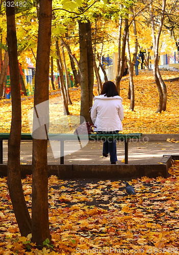 Image of girl on bench in autumn park