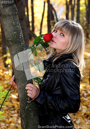 Image of girl with rose in autumn park