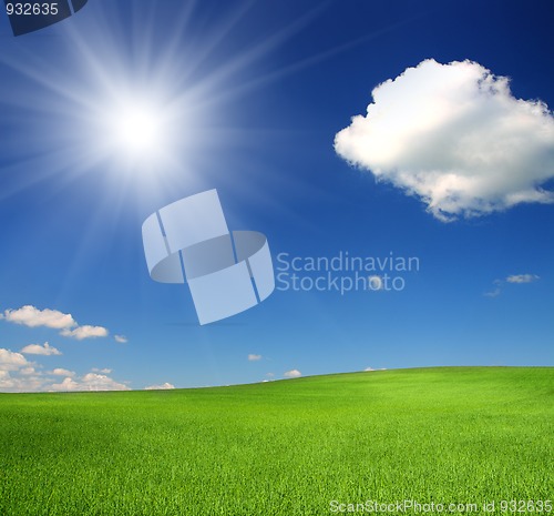 Image of green hill under sky with sun