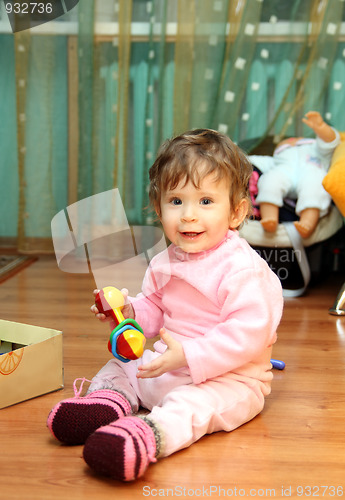 Image of baby girl with toy on floor