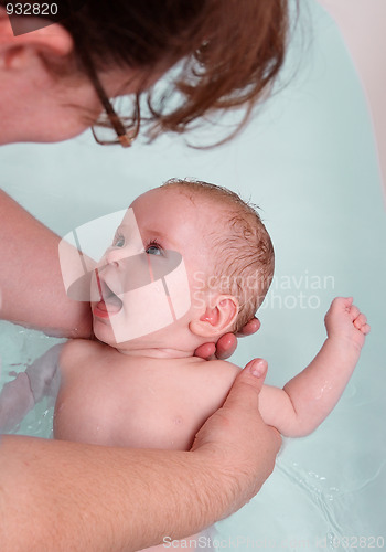 Image of happy baby girl bath by mother