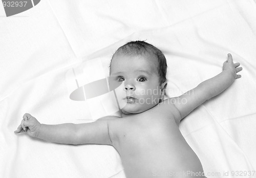 Image of baby lying on white sheet