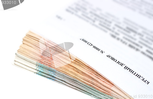 Image of credit contract on stack of money