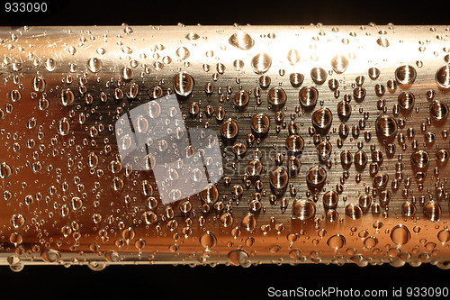 Image of water drops on golden metal