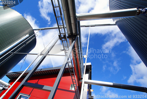 Image of industrial pipelines on pipe-bridge against blue sky 