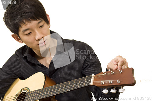 Image of asia boy plays his guitar 