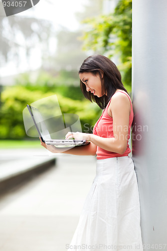 Image of Woman on the phone and working on her laptop