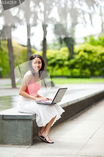 Image of Woman on the phone and working on her laptop