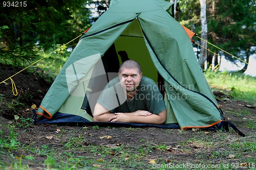 Image of big smiling man in camping tent