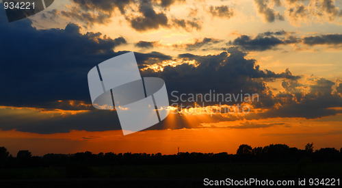 Image of sun behind dark clouds in sky
