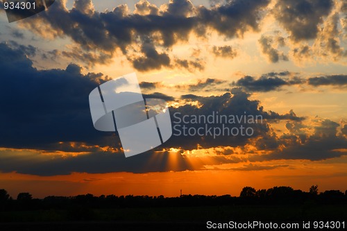 Image of sun behind dark clouds in sky