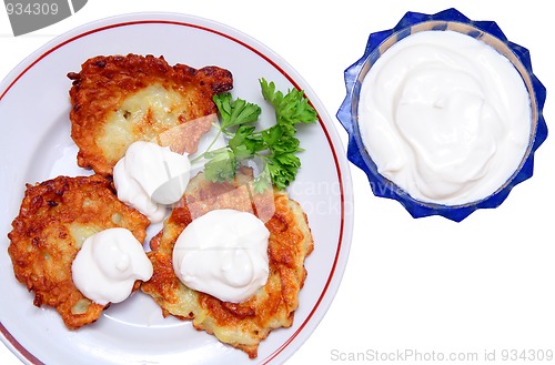 Image of potato pancakes with sour cream isolated on white