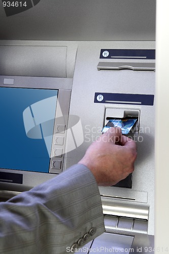 Image of hand inserting card into cash dispense