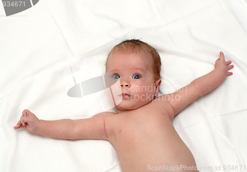 Image of baby lying on white sheet