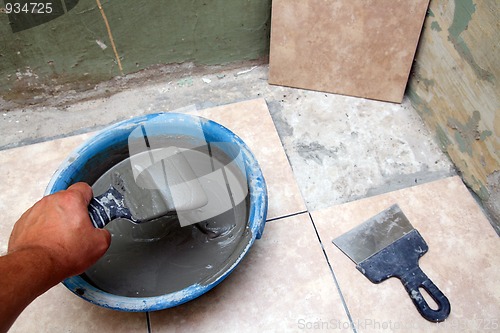 Image of worker laying ceramicson floor