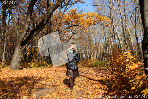 Image of girl walking in autumn park alley