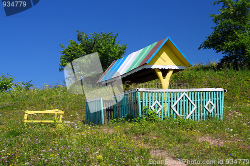 Image of rustic arbour with well