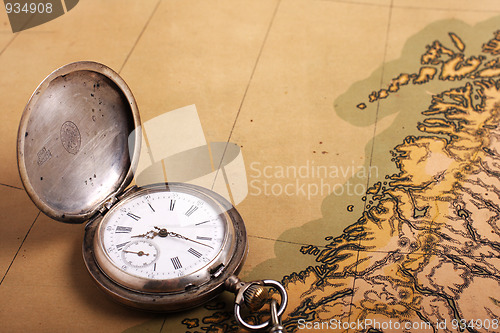 Image of Old silver watch on ancient map