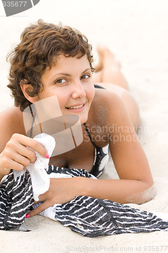 Image of brunet woman lying on a sand