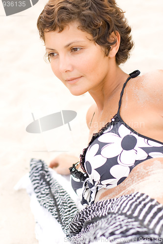 Image of brunet woman lying on a sand