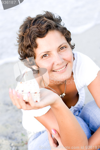 Image of woman on seacoast with a cockleshell