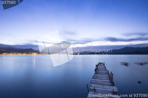 Image of a romantic blue sunset with a jetty over a lake with an evening 