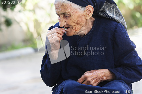 Image of Elderly woman eating cherry