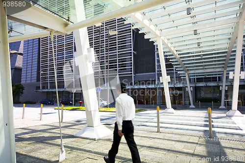 Image of Businessman walking in modern building outdoor