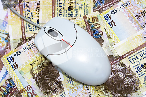 Image of computer mouse placed on $500 hongkong dollar bills 