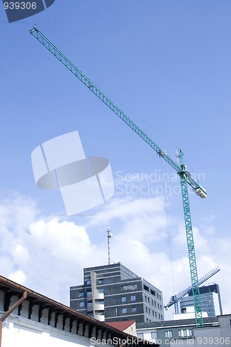 Image of tower crane working on construction on blue sky