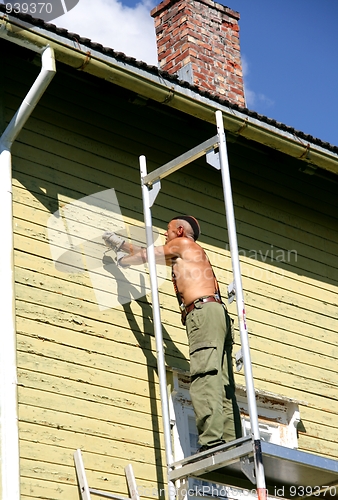 Image of Man scraping off old paint