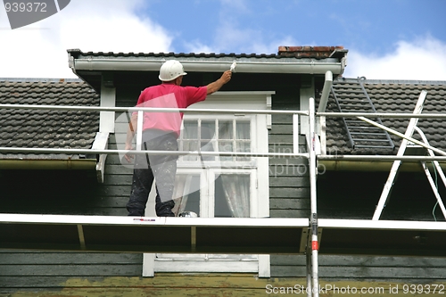 Image of Man painting a house