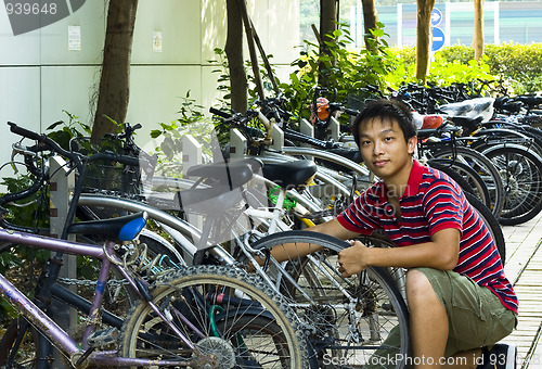 Image of asia boy fix his bike